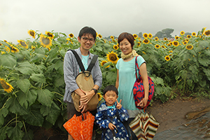 写真：ひまわりの中、笑顔の家族