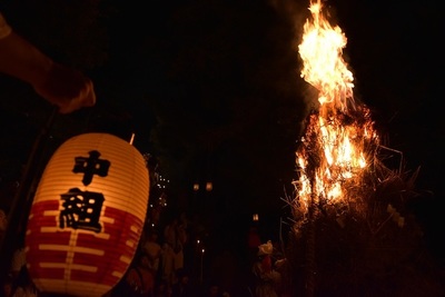 写真：燃え上がる大松明と「中組」と書かれた提灯